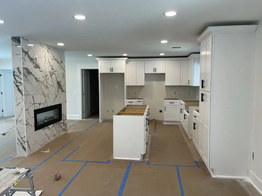 Modern kitchen under renovation with marble accent.