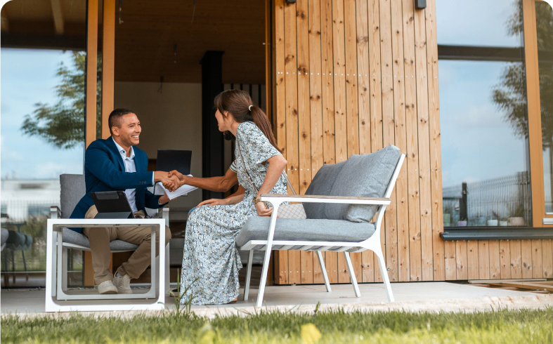 Man and woman shaking hands outdoors.