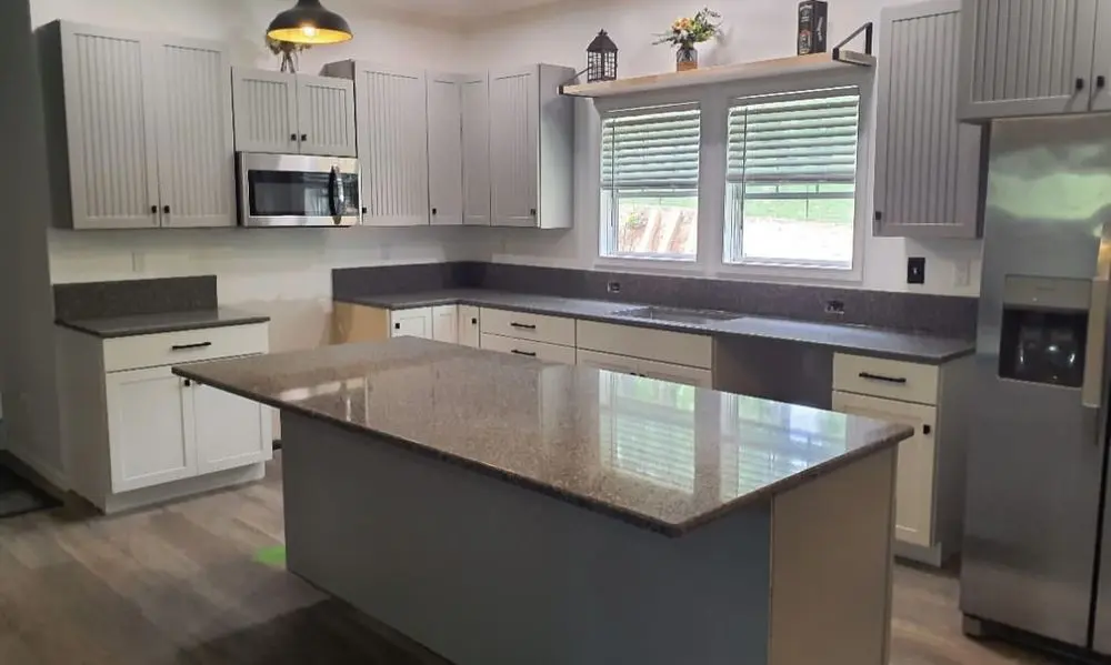 Modern kitchen with island and stainless appliances.