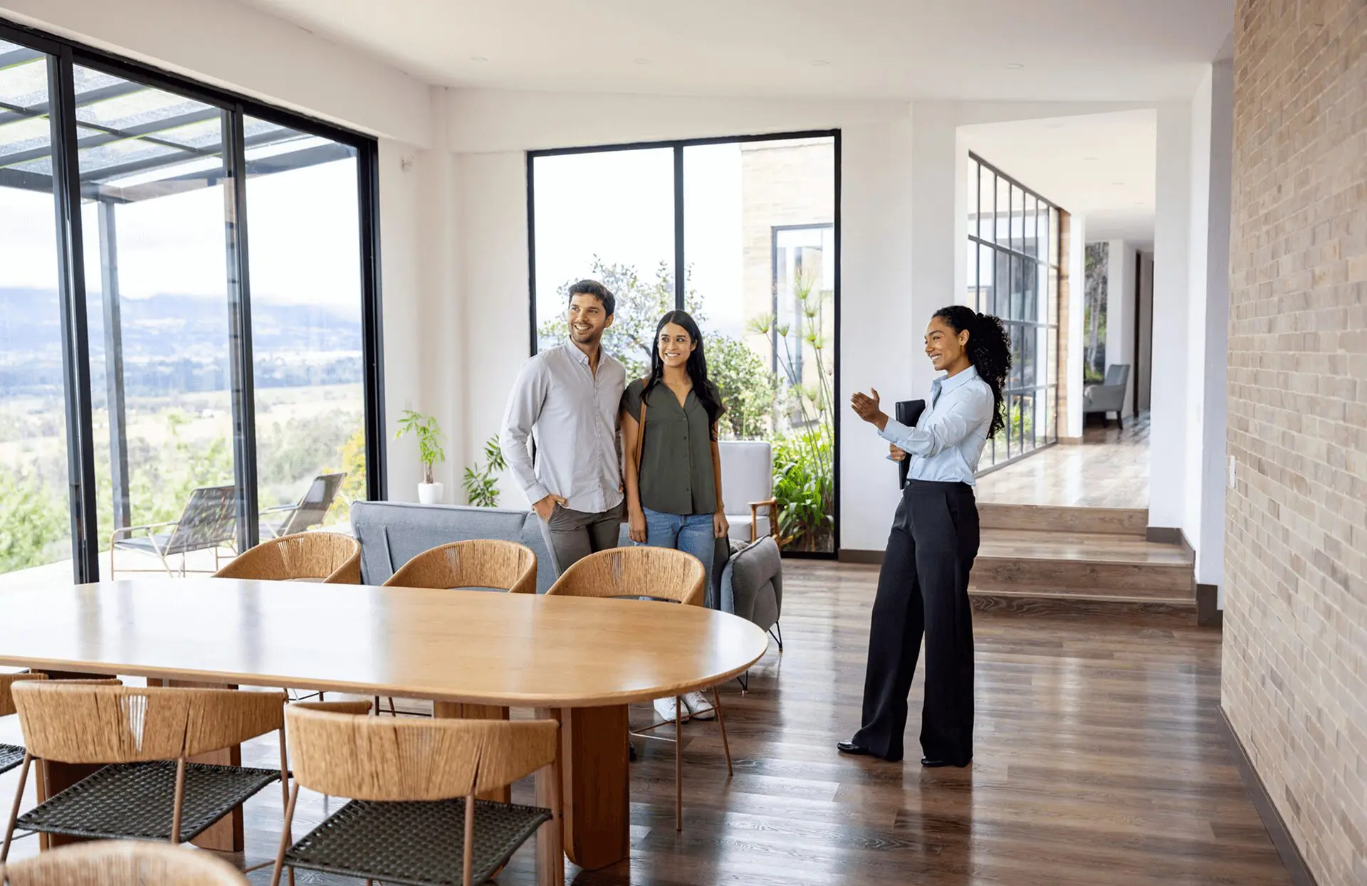 Real estate agent showing couple modern house.