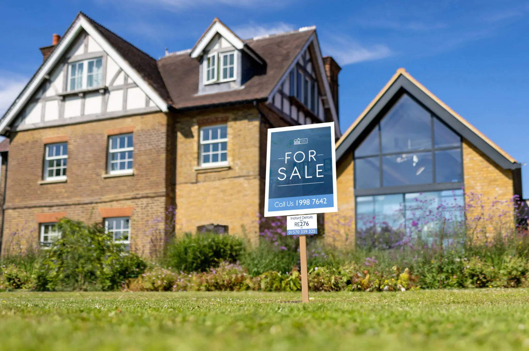 House with "For Sale" sign in yard.